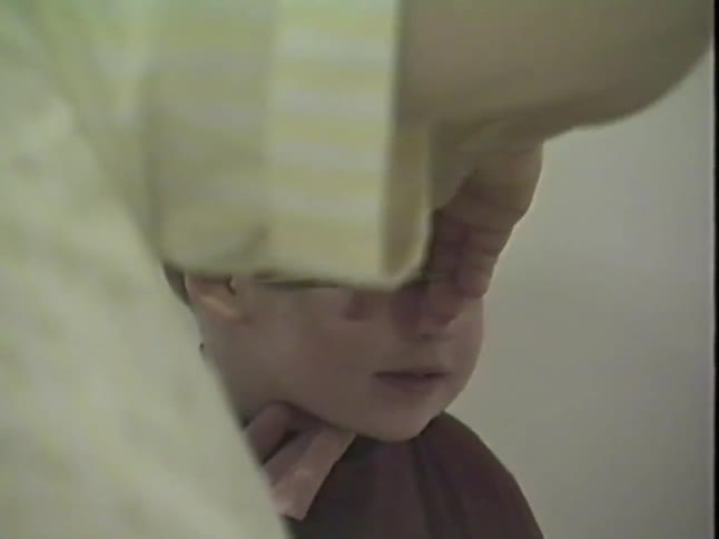 Authentic vintage footage captures a cute young boy getting his first haircut at home with his mother and grandmother