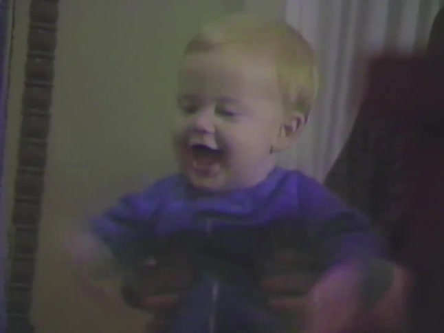 Vintage VHS footage of an adorable and excited baby laughing and waving its arms while being held