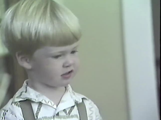 Vintage VHS footage shows a charming little boy with blond hair talking and smiling inside his home