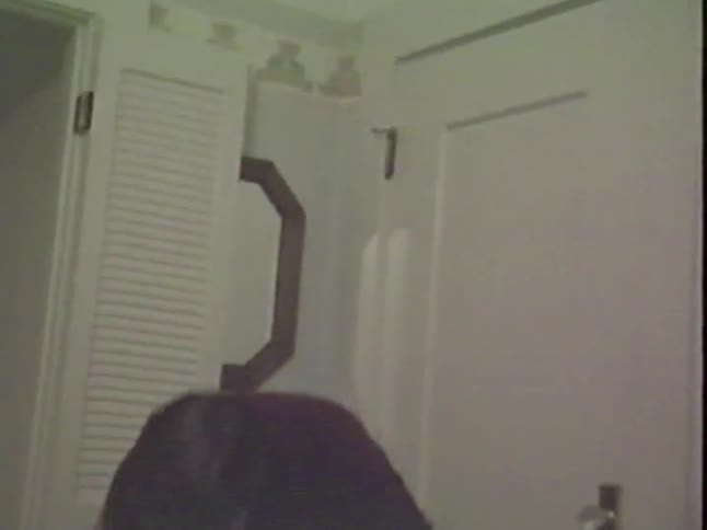 Vintage VHS footage captures a silly father with a mustache playfully wrestling with his toddler on the floor at home