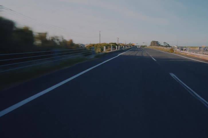 A smooth POV drive along an empty rural road during the beautiful light of golden hour