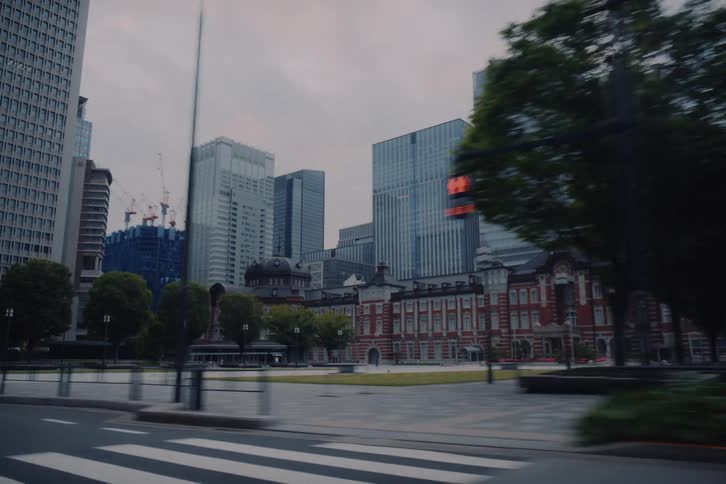 Smooth gimbal driving shot passing the historic Tokyo Station and modern skyscrapers in the Marunouchi district