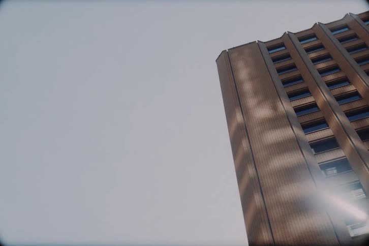 A vintage-style driving point-of-view tour through a modern city, capturing the diverse architecture of towering skyscrapers and classic buildings