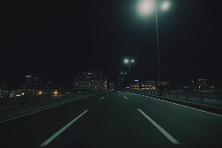 A mesmerizing first-person journey through the illuminated streets and highways of a modern city at night