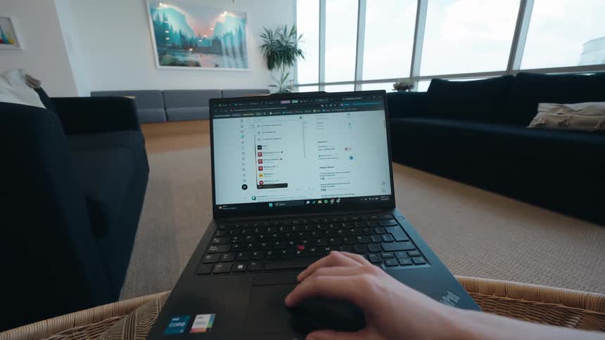 First-person perspective of a person working remotely on a laptop, browsing a website in a modern apartment living room