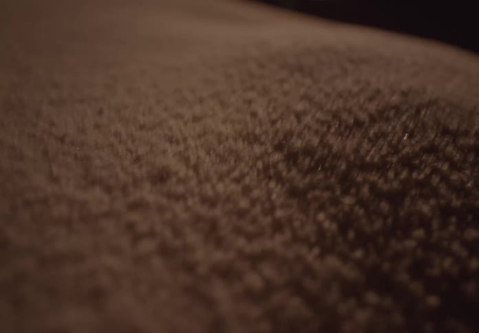A mesmerizing macro shot shows sand particles vibrating and dancing to create hypnotic patterns in warm light
