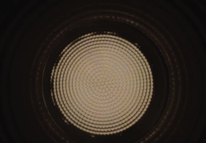 A mesmerizing zoom through a dark ribbed tunnel revealing a complex and hypnotic kaleidoscopic light pattern