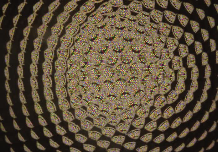 A mesmerizing and hypnotic kaleidoscopic spiral of colorful, repeating patterns slowly twists and warps