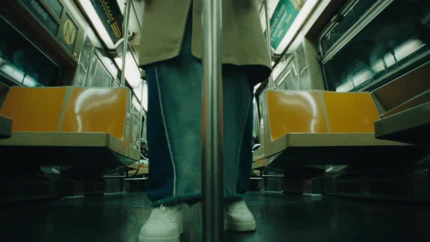 An artistic and surreal montage of a person in a karate uniform and flower mask practicing in a room and another person standing on an empty subway