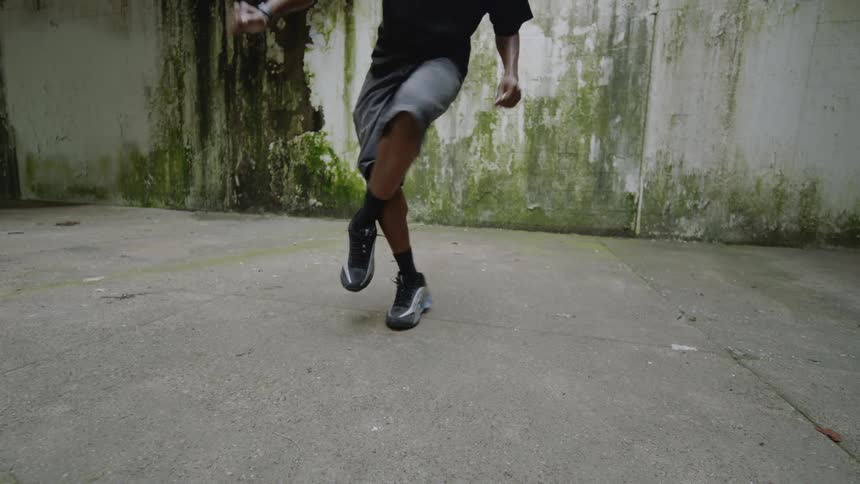 Slow motion close-up of a street dancer's feet showing intricate hip-hop moves on a concrete surface