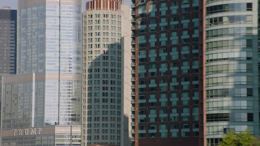 A close-up tracking shot reveals the dense cluster of modern skyscrapers in downtown Chicago on a sunny day