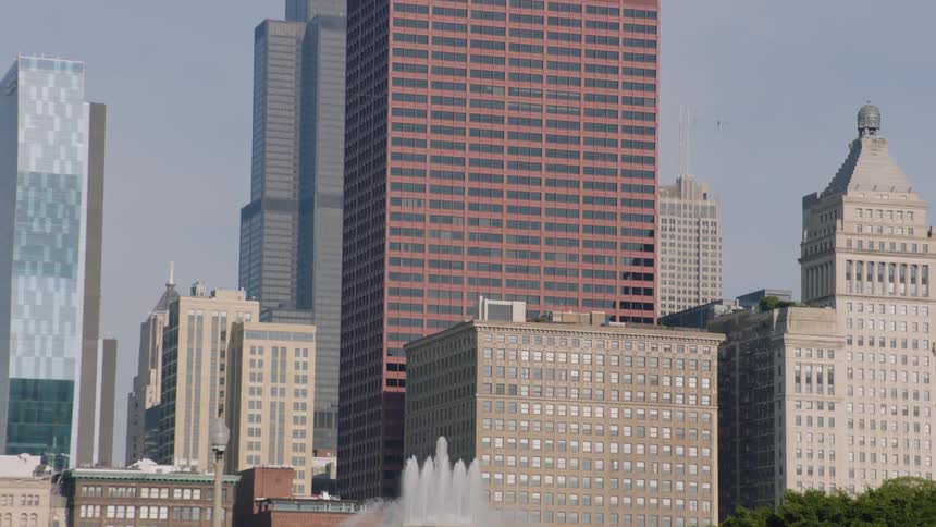 A beautiful view of Chicago's Buckingham Fountain with the iconic city skyline rising in the background on a sunny day
