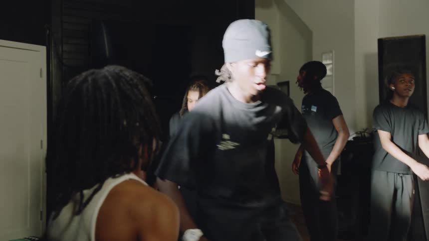 Slow motion close up of energetic footwork reveals a group of young men passionately practicing a hip-hop dance routine in a studio