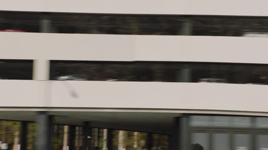 A dynamic tracking shot of various city buildings and skyscrapers passing by from a moving vehicle's perspective