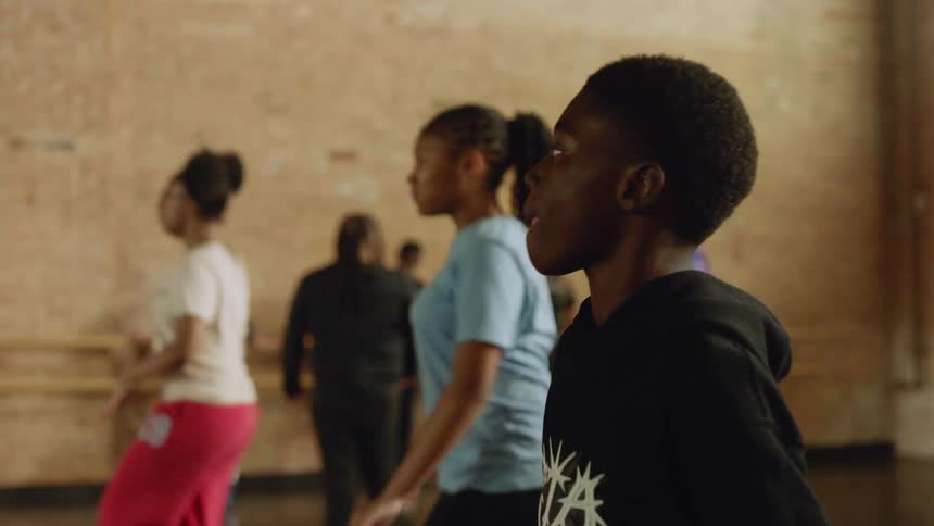 Young Black dancers practice a hip-hop routine in a dance studio during a class in slow motion