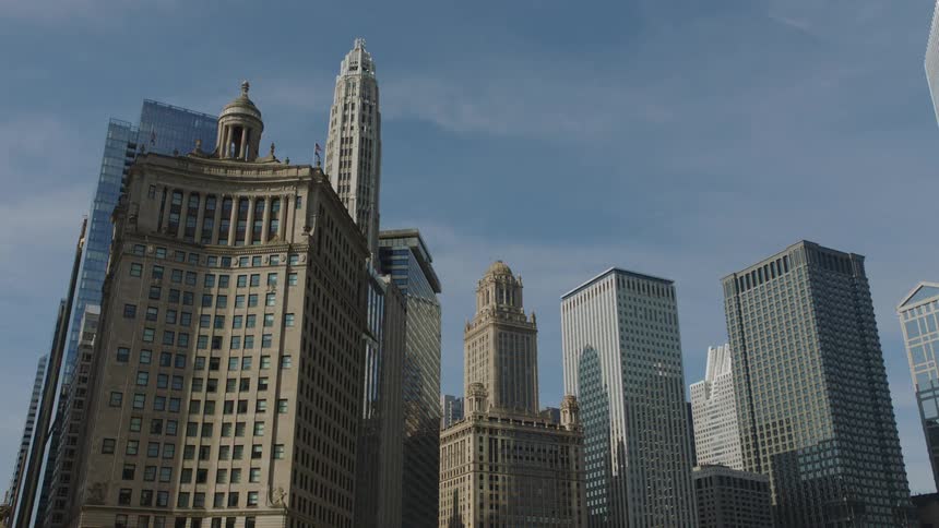 A low-angle view showcases the impressive architecture of downtown Chicago's skyscrapers against a clear blue sky