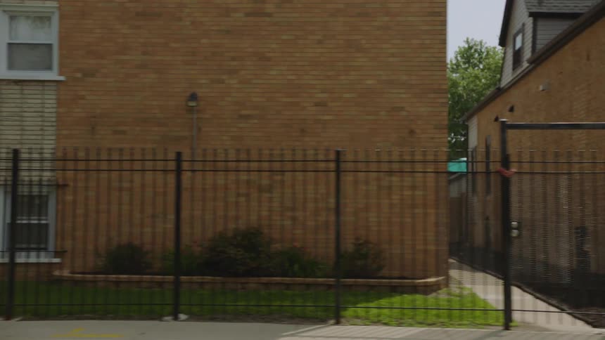 Slow-motion tracking shot of residential buildings and houses in an urban neighborhood during the day