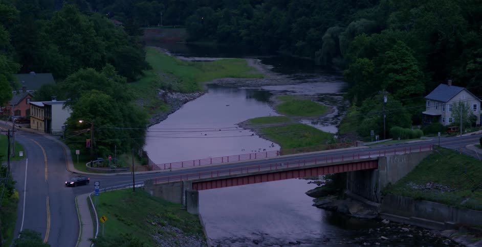 A car drives over a bridge in a village