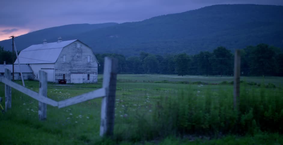 A large barn is on the field ahead