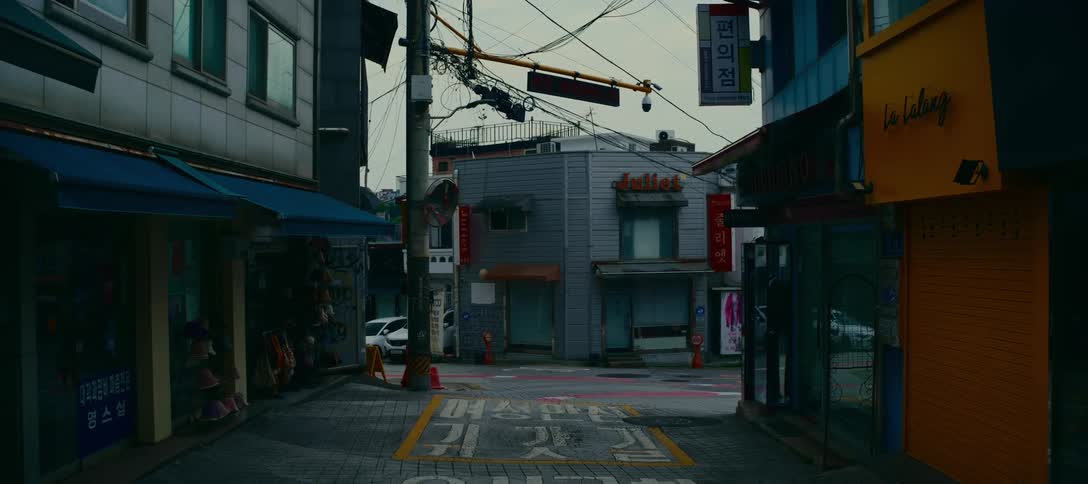 A static shot of a quiet, empty street with closed shops in an urban area of Korea