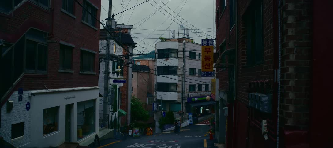 A static shot down a sloping street in a quiet neighborhood of Seoul, South Korea on a moody, overcast day