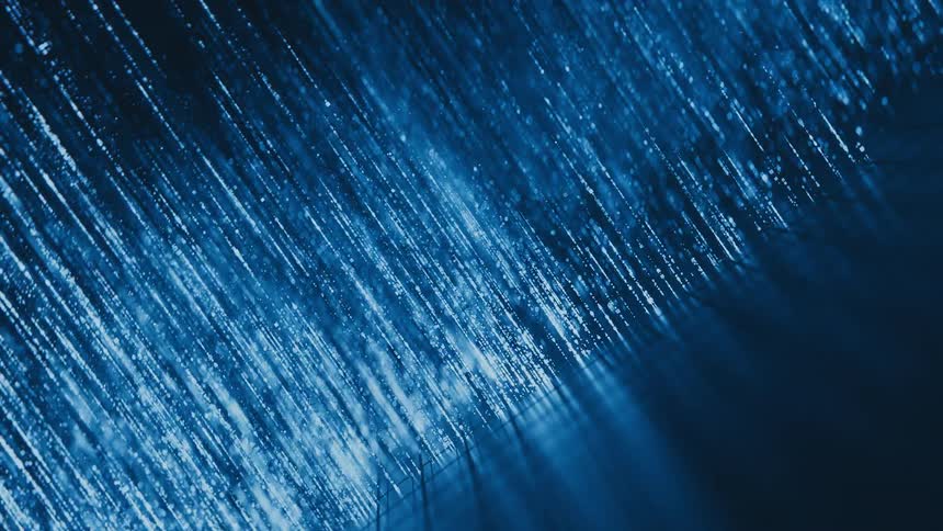 Abstract diagonal streams of shimmering blue particles create a futuristic technological background