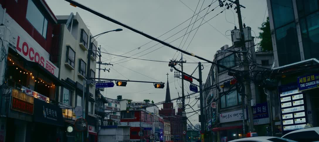 Tangled electrical wires cross over a city street in Seoul, South Korea on a gloomy day