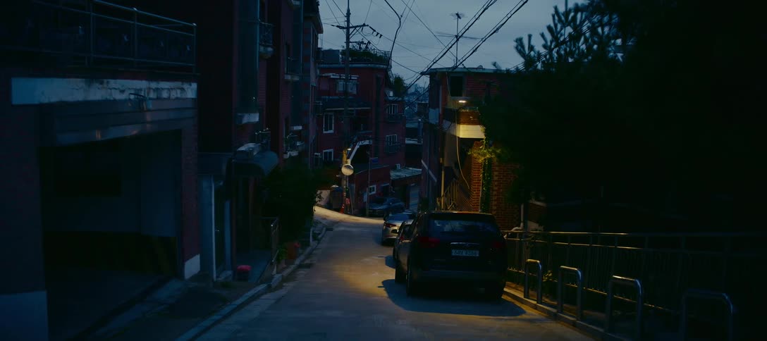 A static shot of a dark and quiet residential street in an Asian city at dusk