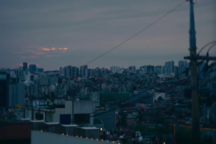A calm and moody cityscape of Seoul, South Korea, at dusk under an overcast sky