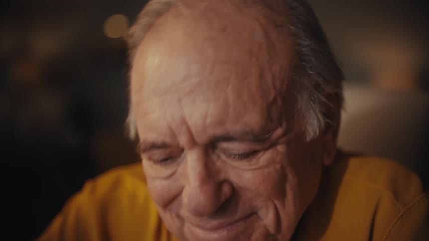 A close-up of an emotional elderly man taking off his glasses, his face full of nostalgia as he reflects on fond memories in slow motion