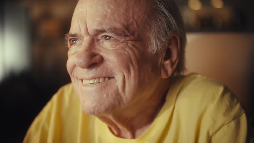 A heartwarming close-up of an elderly U.S. Army veteran laughing and reminiscing with joy
