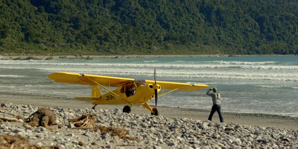 A man walks towards his yellow plane