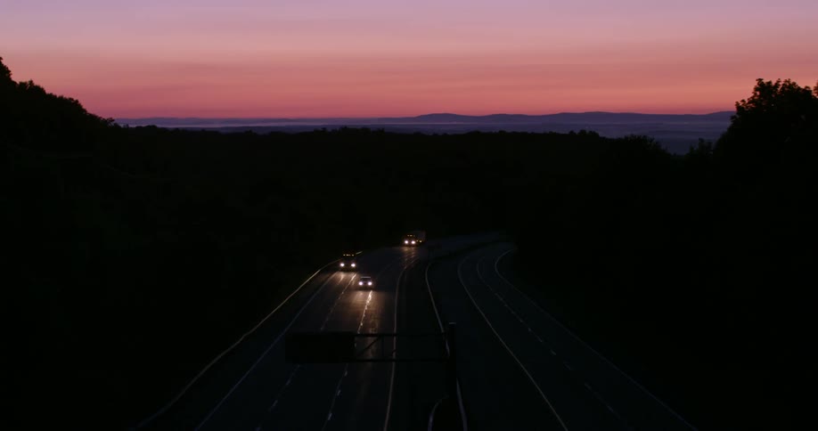 Cars drive down the road at dawn