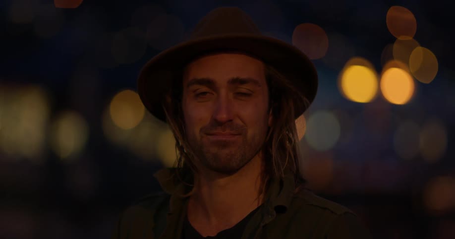 Man smiling outside at night