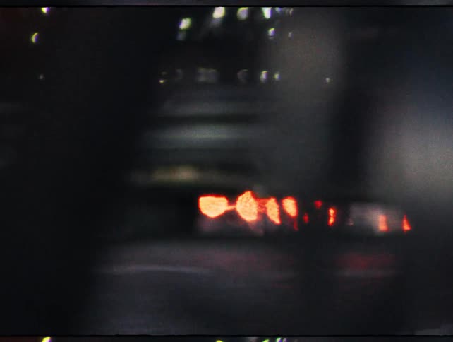 Abstract bokeh lights from cars, buses, and bicycles create a dreamy urban scene from a low-angle perspective on a city street at night