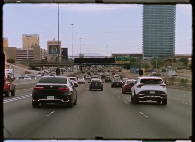 A point-of-view shot from a car driving in traffic on a Las Vegas highway during the day, with a vintage film aesthetic