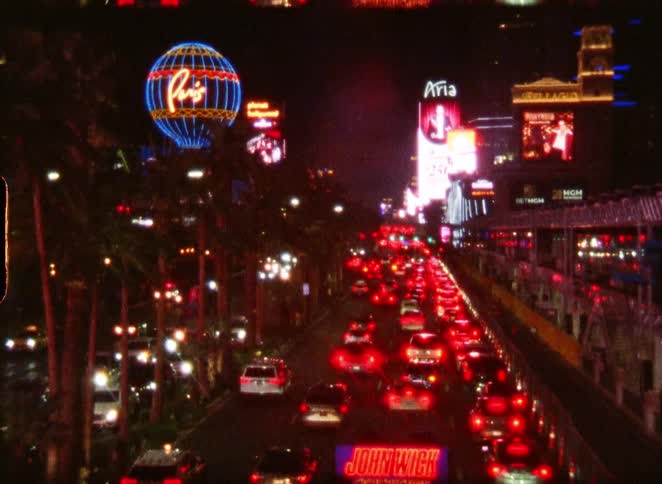 Vintage film footage captures the vibrant neon lights and heavy traffic on the Las Vegas Strip at night
