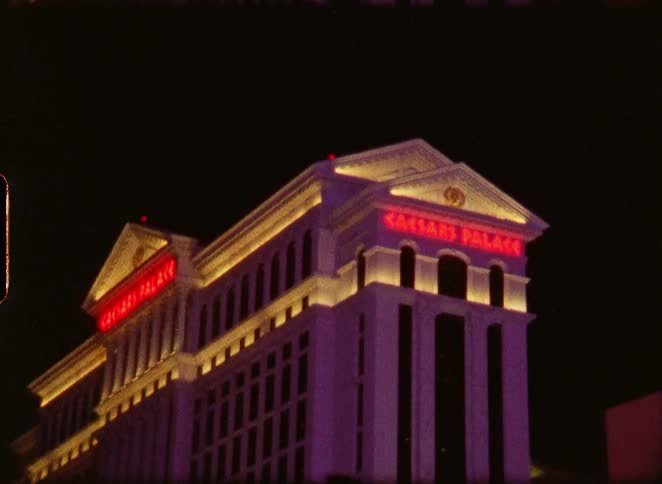 Vintage film shot of the famous Caesars Palace hotel and casino illuminated at night in Las Vegas