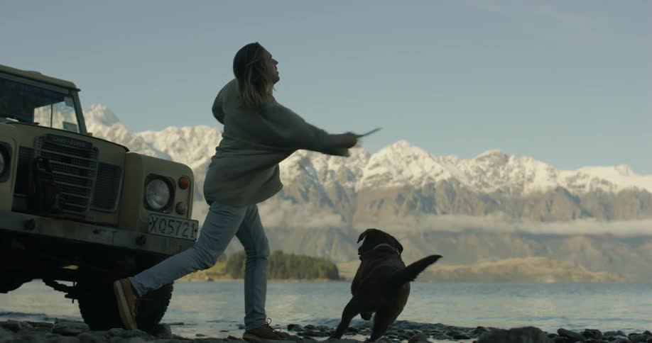 Man throws a stick for his dog to fetch