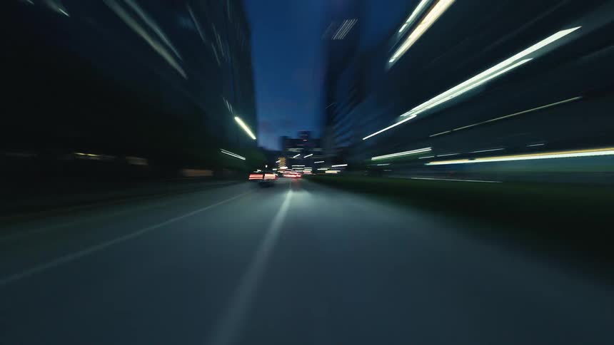 An exhilarating POV hyperlapse captures the speed and energy of driving through a bustling city at night