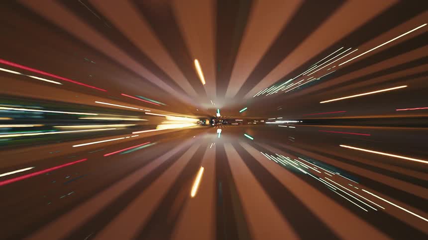 Driving at warp speed through a futuristic city at night, a kaleidoscopic time-lapse of blurred lights creates a visual tunnel