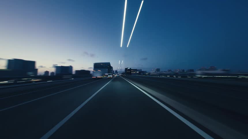 A thrilling point-of-view hyperlapse of driving on a city highway at dusk, with traffic and city lights creating beautiful light streaks