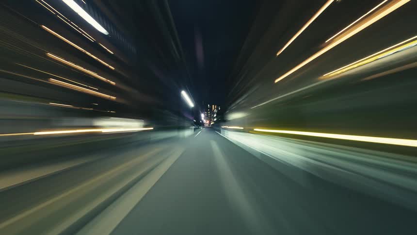 A high-speed POV hyperlapse drive through a futuristic city at night, with vibrant motion-blurred light trails
