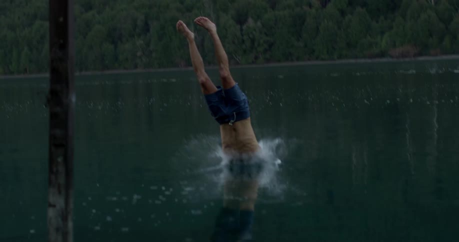 Man dives off a dock into a lake