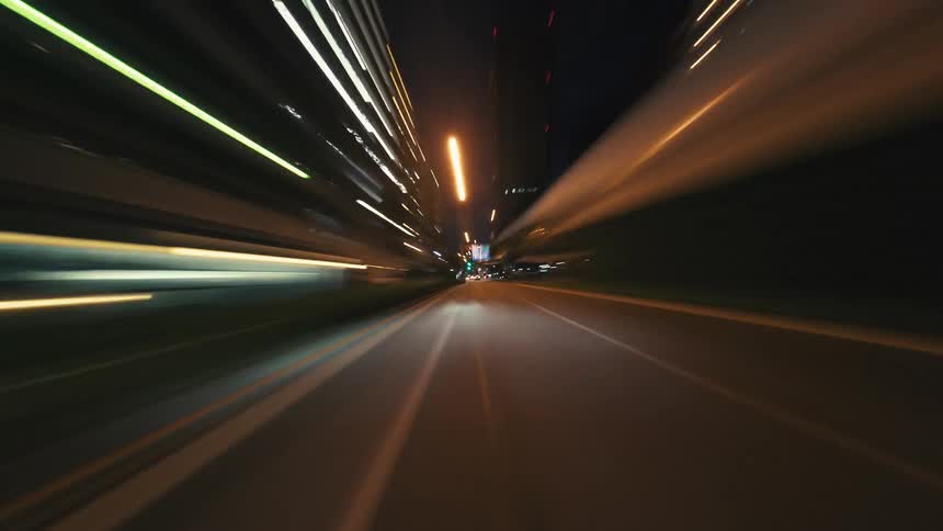 An exhilarating point-of-view hyperlapse of driving through a bustling city at night, where lights streak across the screen
