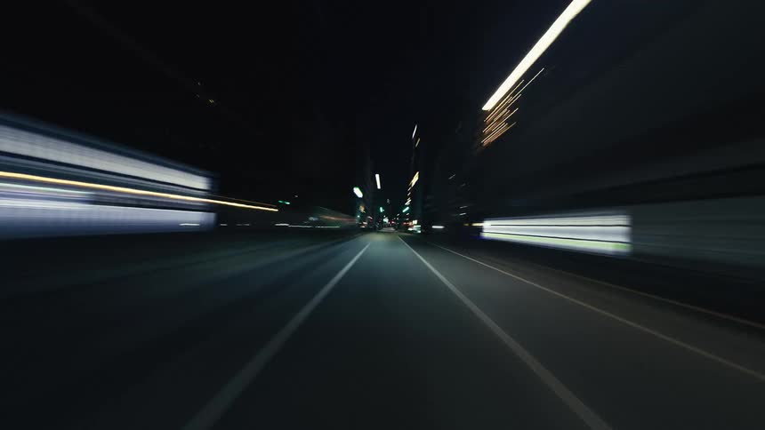 First-person perspective hyper-lapse of driving through a bustling city at night, with mesmerizing light trails creating a sense of speed and motion