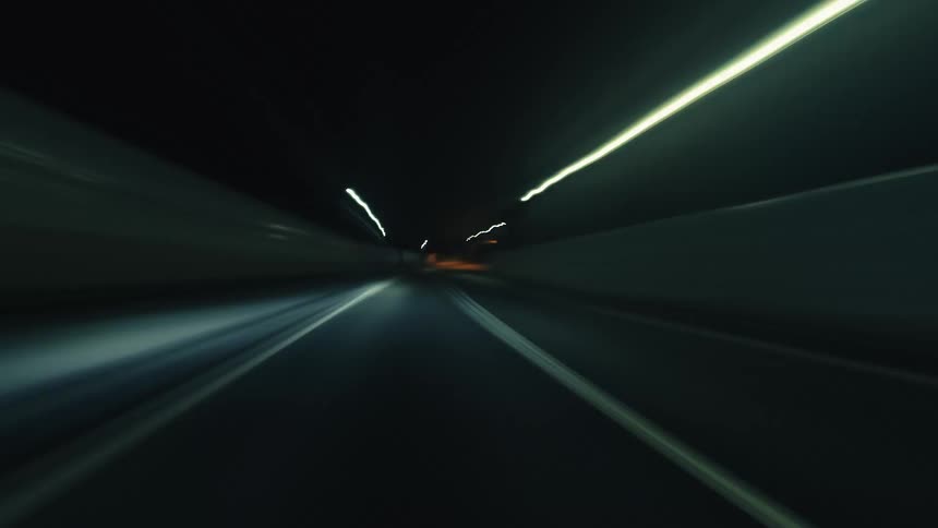 An exhilarating point-of-view hyper-lapse captures the blur of light trails while driving through a city's highways and tunnels at night