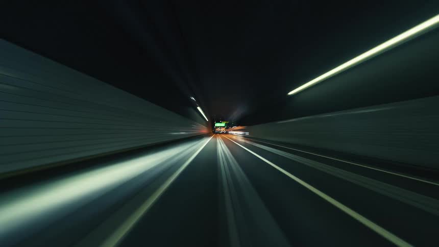 An immersive hyperlapse journey driving through city tunnels and highways at night, with vibrant light trails blurring past