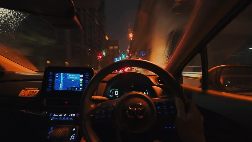 POV hyperlapse of driving through a bustling city at night on a rainy day, with street lights and buildings blurring past