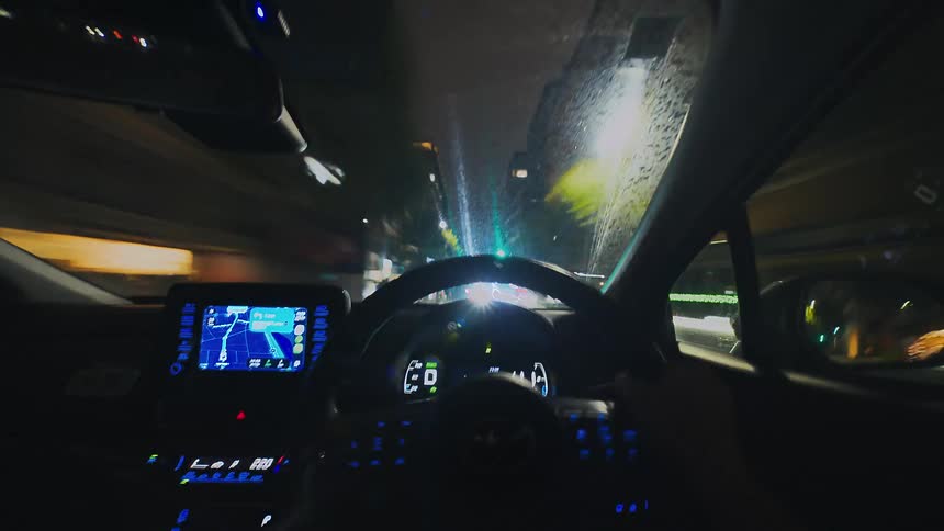 A fast-paced hyperlapse from the driver's perspective shows a car navigating the neon-lit streets of a modern city at night